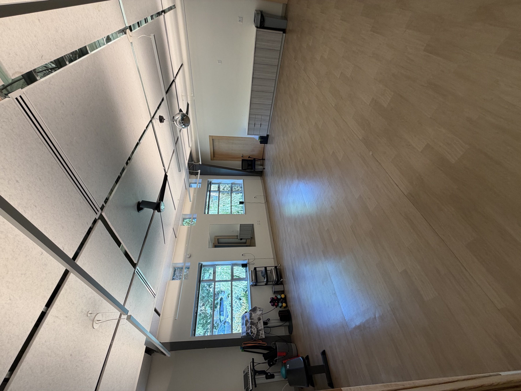The DSR studio — open floor with mirrors, natural light, and ceiling fans